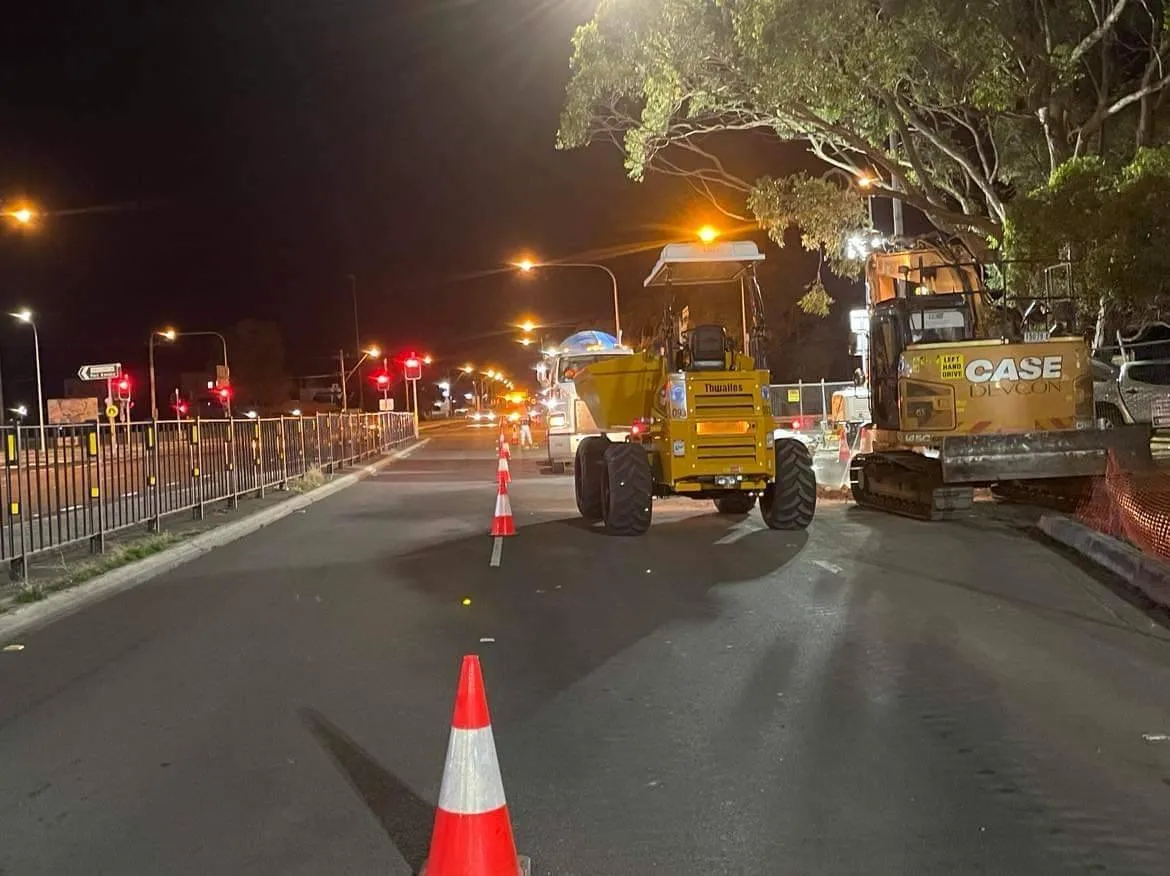 Night works: a roller behind a line of cones under street lights