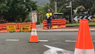 Cones, a road closed sign and a traffic controller at a closure
