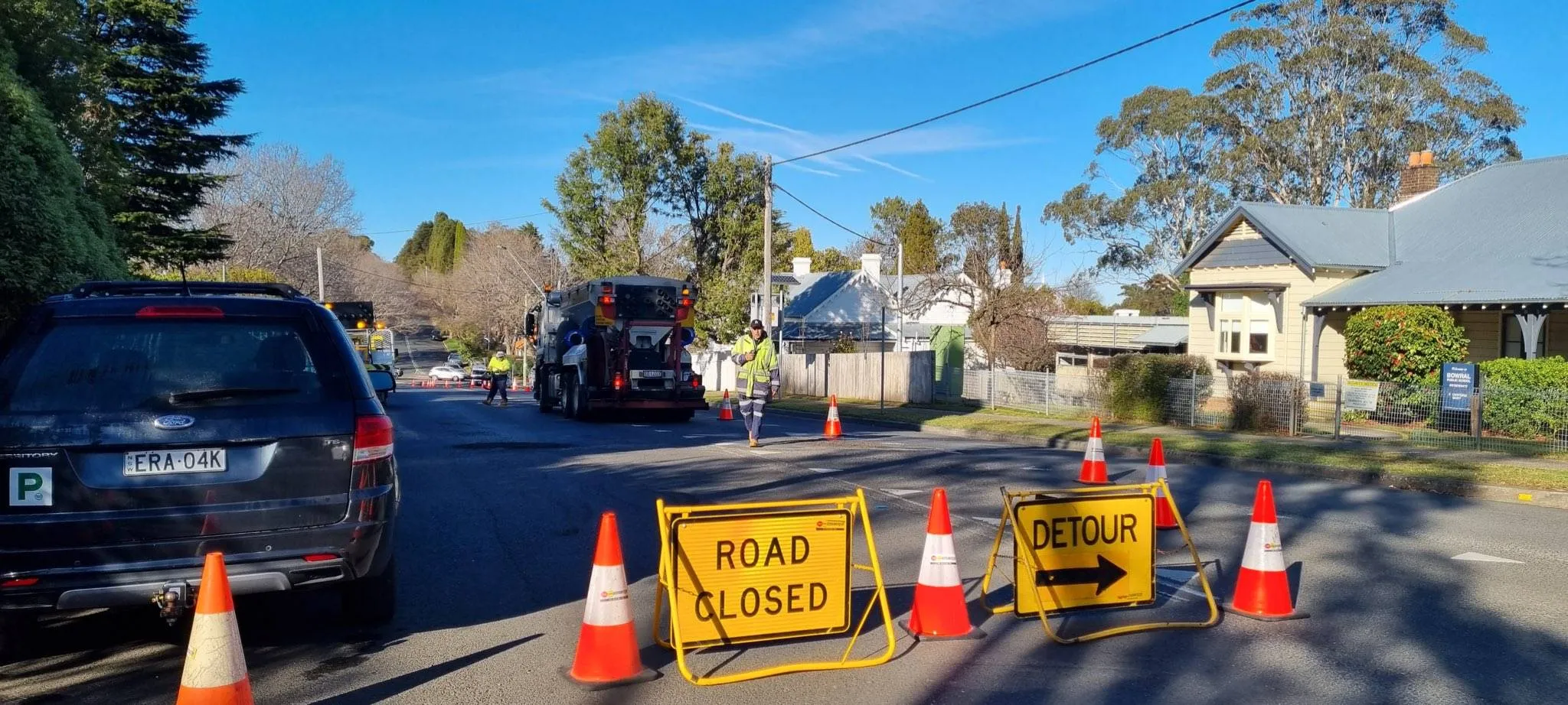 Road closed and detour signs on a suburban street