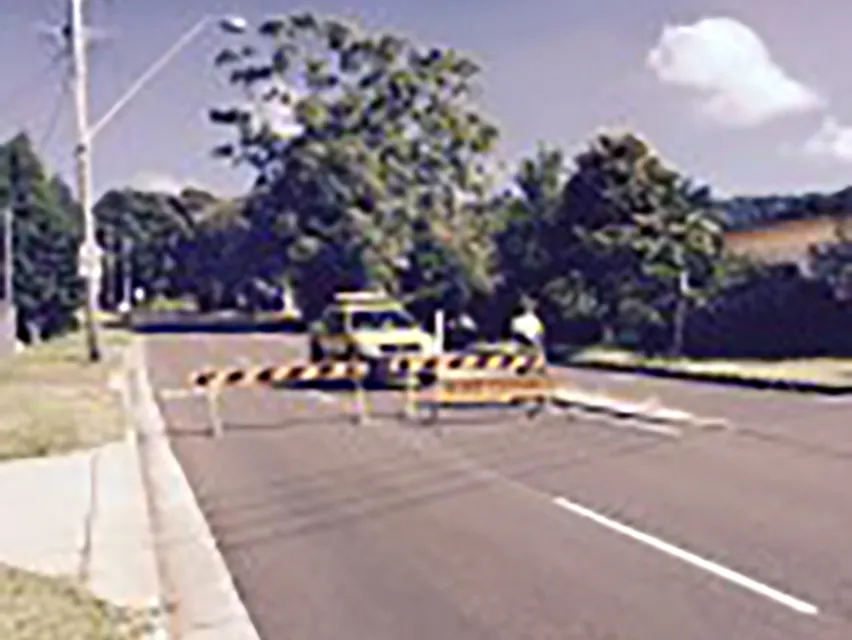 Road closed barriers across a suburban road