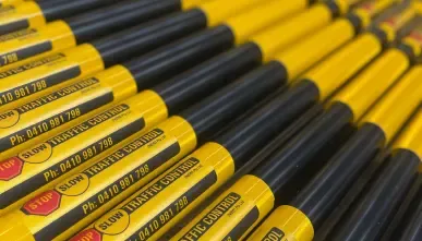 A stack of STOP SLOW bats with the SSTC phone number