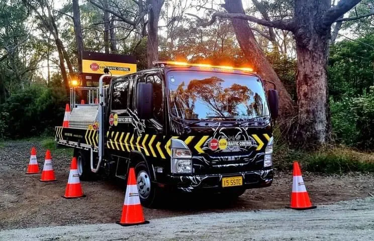 SSTC truck parked in bushland with cones out, lit up at night